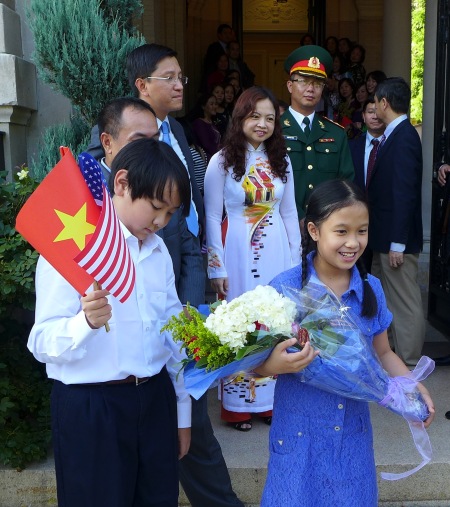 Các cháu tập tặng hoa và nói tiếng Việt. Ảnh: HM