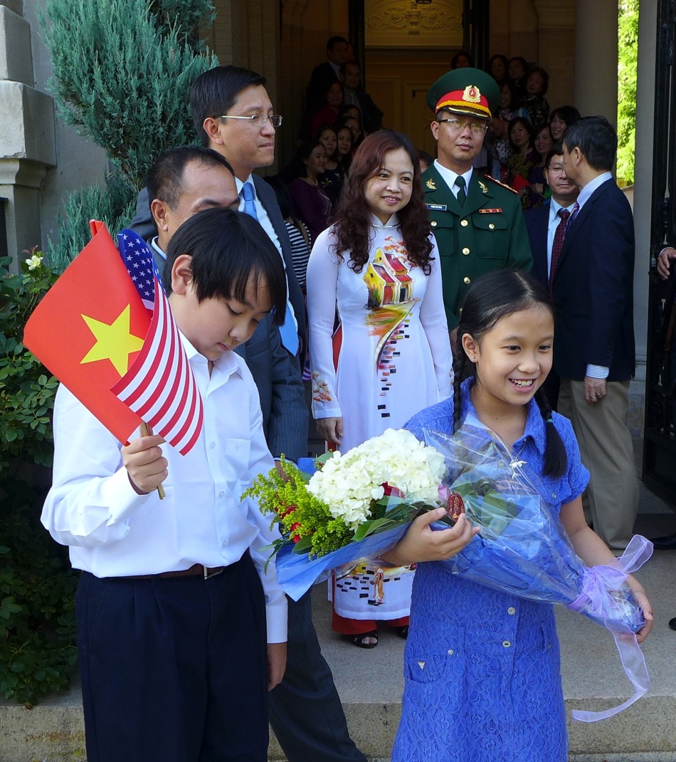 Các cháu tập tặng hoa và nói tiếng Việt. Ảnh: HM